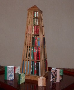 Mini bibliothèque pyramidale, à base carrée de 27cm de haut comprenant environ 140 livres tous différents sur 6 niveaux