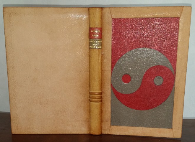 reliure plein cuir beige, dos passé, plat antérieur orné du signe "ying-yang" en chagrin rouge et gris