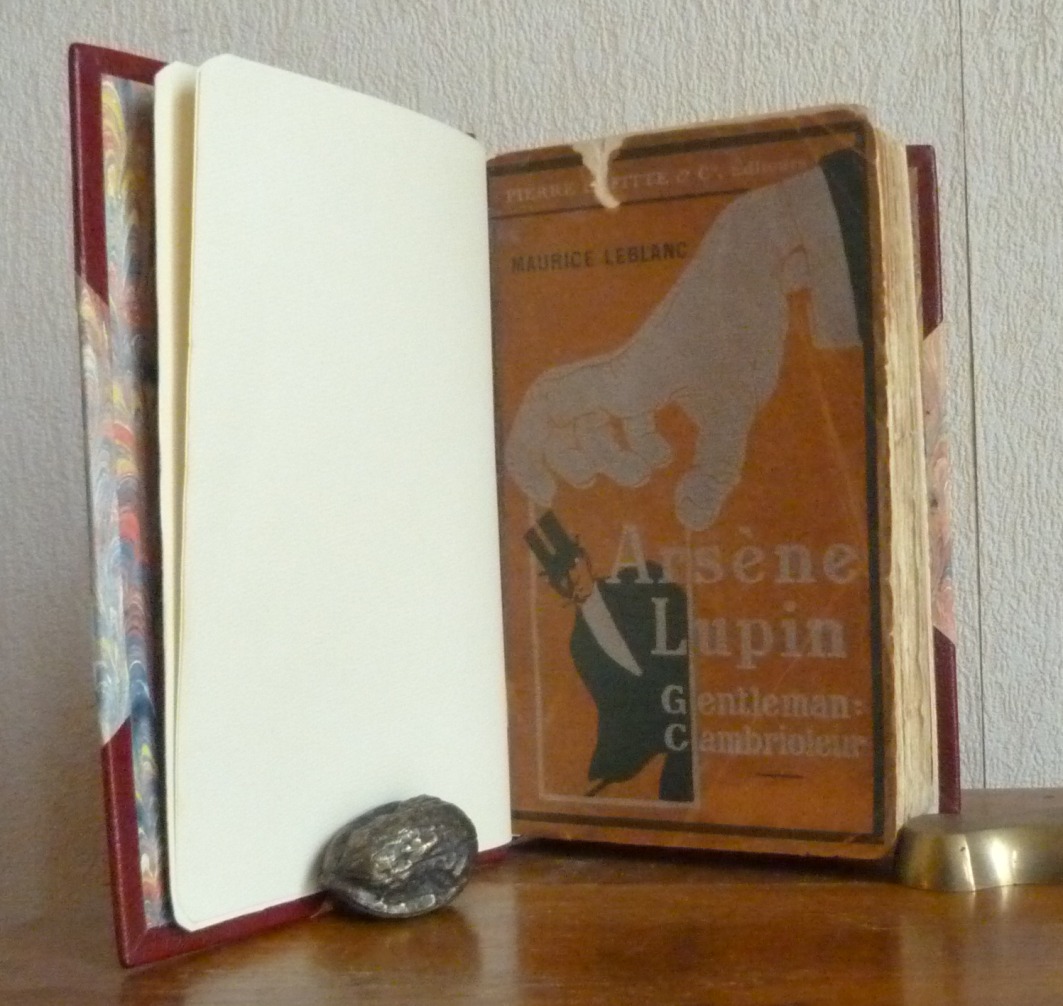 Demi-cuir à coins bordeaux, mosaïques sur le dos du livre reprenant une partie de la couverture du livre