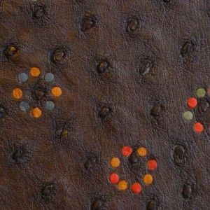 plein cuir d'autruche bordeau foncé, incrustations de cercles formés de petits disque multicolores