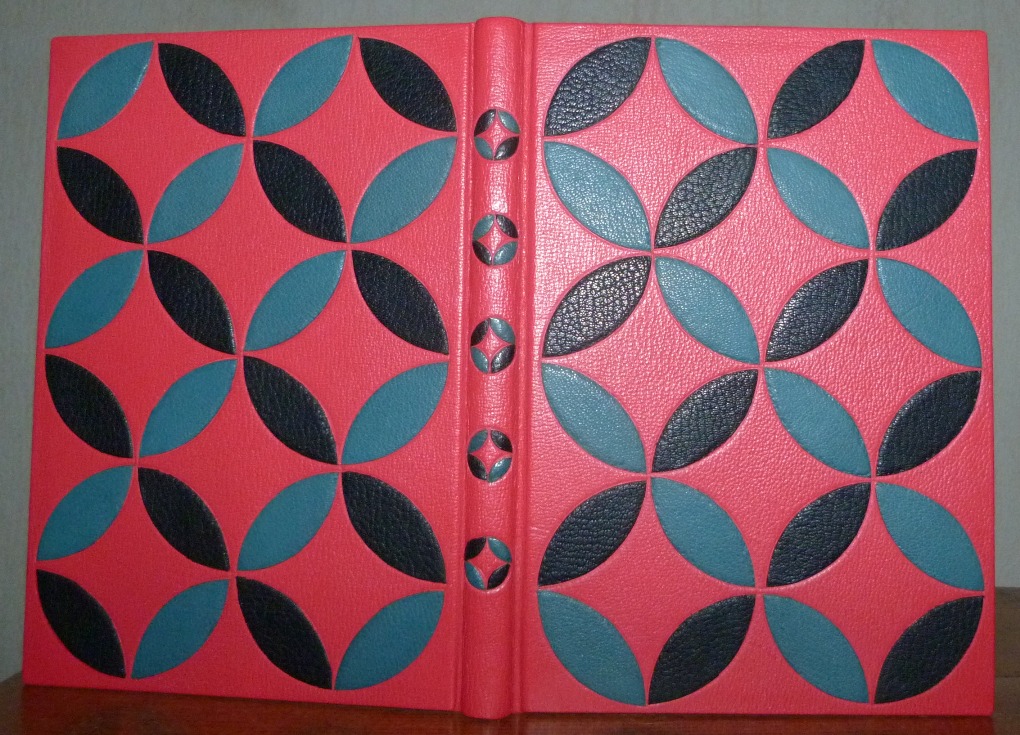 Bradel plein cuir rouge ornés d'arc de cercles, formant des cercles,noirs et bleus