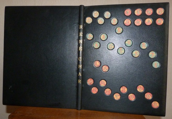 Plein cuir noir, titre à la chinoise, incrustation sur le plat antérieur de disque de papiers craft de différentes couleurs, superposés puis poncés faisant lettres du titre et de l'auteur.