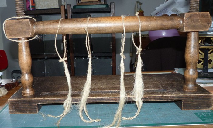 Technique de la reliure de feuilles simoles. Couture sur ficelles dédoublées.