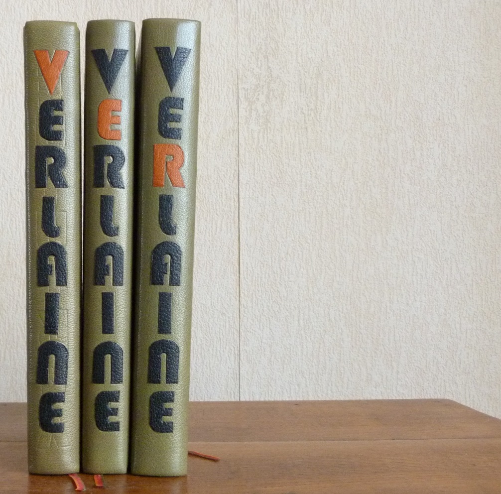 Huit tomes des oeuvres complètes de Verlaine, demi-cuir vert à bandes, VERLAINE mosaiqué sur le dos à la chinoise, en noir, chaque lettre étant succéssivement en orange sur les 8 tomes.