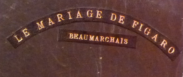 Demi-cuir noir, plats en ardoise, mosaïque en cuir noir et blanc représentant Figaro, 4 nerfs. Détail du titre sur le plat antérieur.