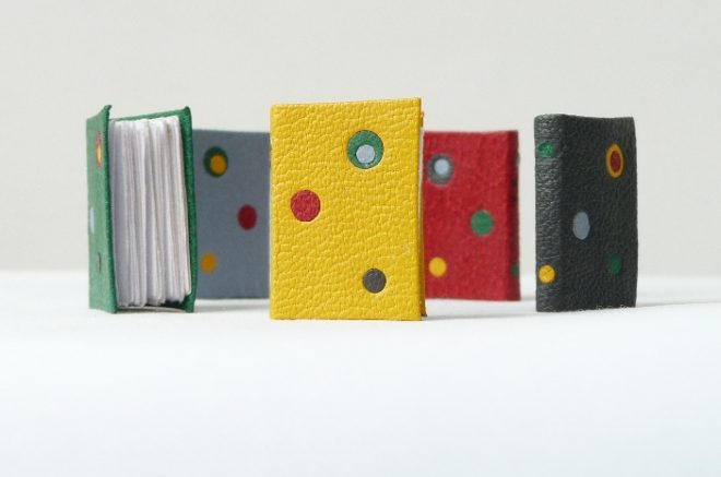 Mini-livres, plein-cuirs de différentes couleurs avec incrustations, à l'emporte pièce circulaire, de différentes couleurs.