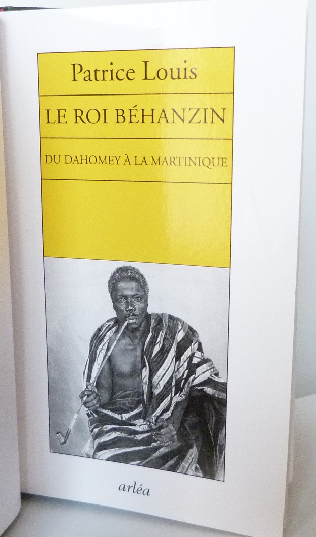 Demi-cuir vert, collé à celui-ci 2 rectangles superposés jaune et rouge, le tout représentant à droite ou à gauche le drapeau béninois. Tranchefile tricolore reprenant le drapeau béninois que l'on retrouve aussi sur la tranche de tête. Une de couverture de : "Le roi Béhanzin. Du Dahomey à la Martinique."