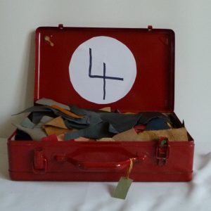 Chutes de cuir.5 valises rouges en fer contenant le matériel dont j'ai besoin pour faire les décors de la reliure.