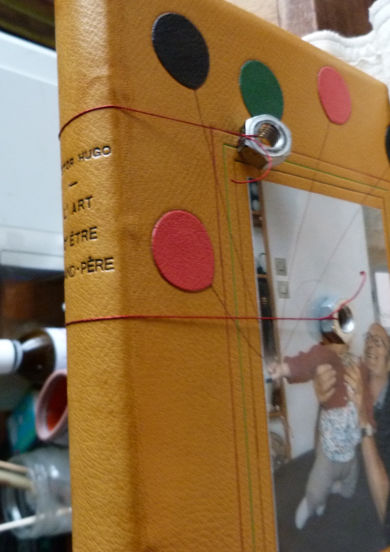Dos du livre avec du fil de lin lestés aux deux extrémités de 2 écrous pour simuler les filets.