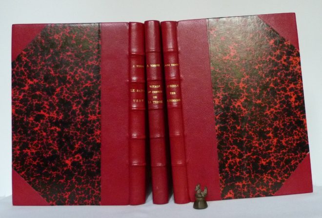 3 romans de Jules Verne, reliés en demi-cuir rouge à coins, utilisation de papier Anonnay rouge.